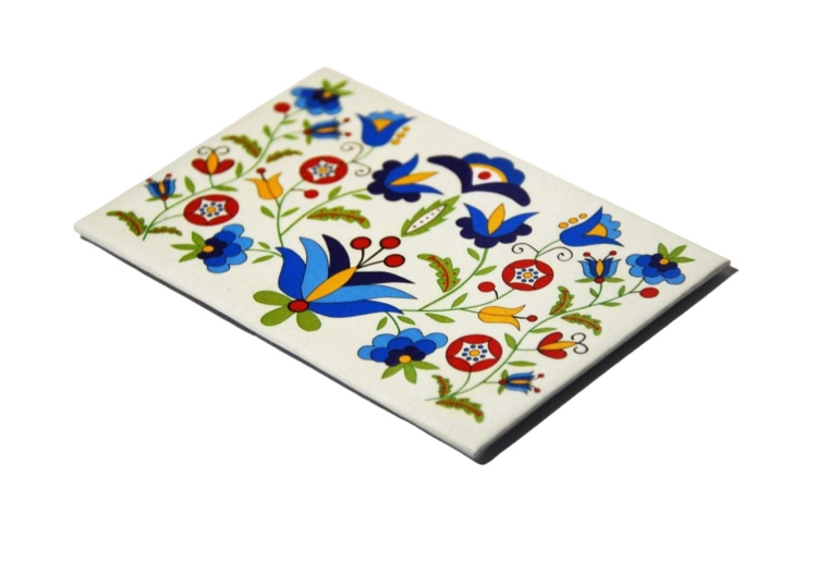 Magnes z haftem wejherowskim, kolorowy wzór kaszubski na tle białego kartonika – regionalna ozdoba lodówki.