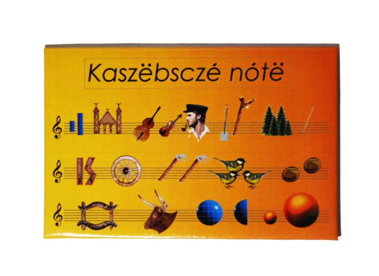 Magnes Kaszubskie Nuty z kolorowym wzorem przedstawiającym symbole kaszubskiej wyliczanki, na żółtym tle, na lodówce – produkt regionalny, kaszubski folklor, dekoracyjny gadżet.