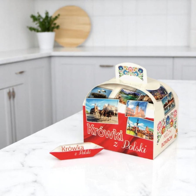 Krówka – pamiątka z Polski to elegancki kuferek wypełniony pysznymi krówkami śmietankowymi. Całość zapakowana w ozdobny kartonik zdobiony tradycyjnymi łowickimi wzorami, a każda krówka w folkowym papierku.