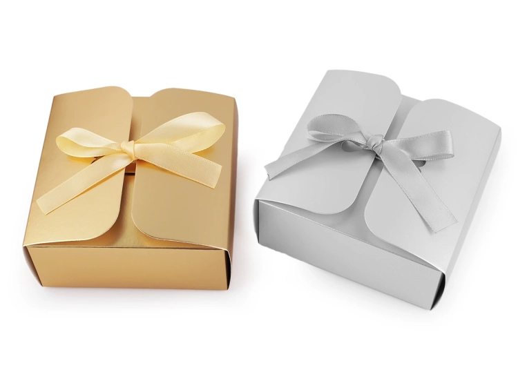 Złote pudełko prezentowe z satynową wstążką to elegancki sposób na zapakowanie drobnych upominków. Po złożeniu tworzy efektowne serca – gotowe na wyjątkowe okazje