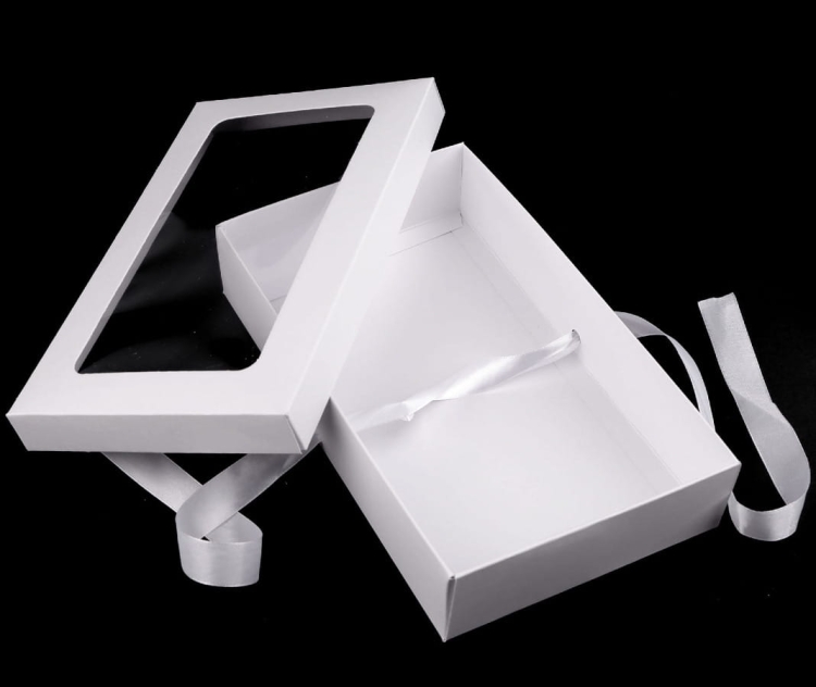 Pudełko papierowe z dużym okienkiem i rypsową wstążką w kolorze białym i ciemno pudrowym – eleganckie opakowanie do eksponowania zawartości.