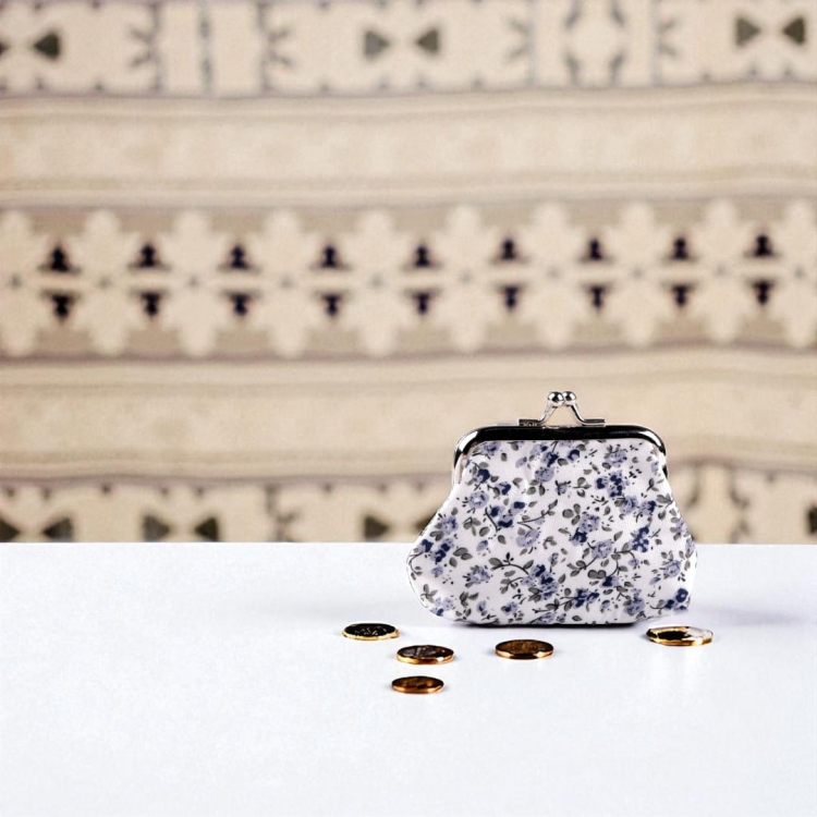 Mała portmonetka retro w niebieskie kwiaty na białym tle, z metalowym zapięciem typu klik.