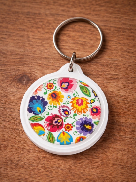 Okrągly_bialy_breloczek_z_motywem_lowickim_kwiaty_folk.jpg